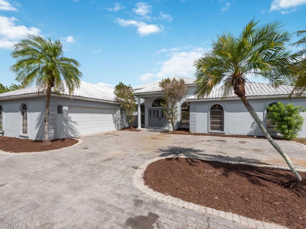 7016 Trail Boulevard Naples, FL 34108 - Photo 1 of 26 a view of a house with a yard and palm trees