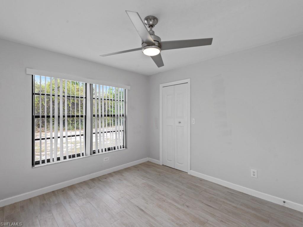 7016 Trail Boulevard Naples, FL 34108 - Photo 15 of 26 a view of an empty room with wooden floor and a window