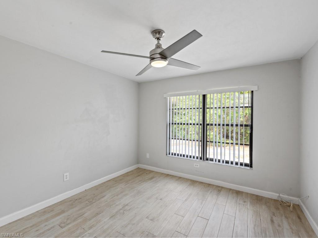 7016 Trail Boulevard Naples, FL 34108 - Photo 17 of 26 wooden floor in an empty room with a window