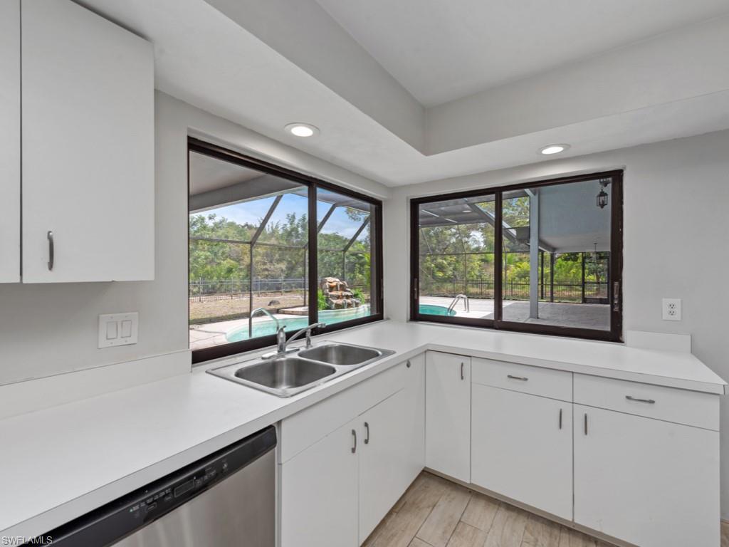 7016 Trail Boulevard Naples, FL 34108 - Photo 10 of 26 a kitchen with sink a large window appliances and cabinets