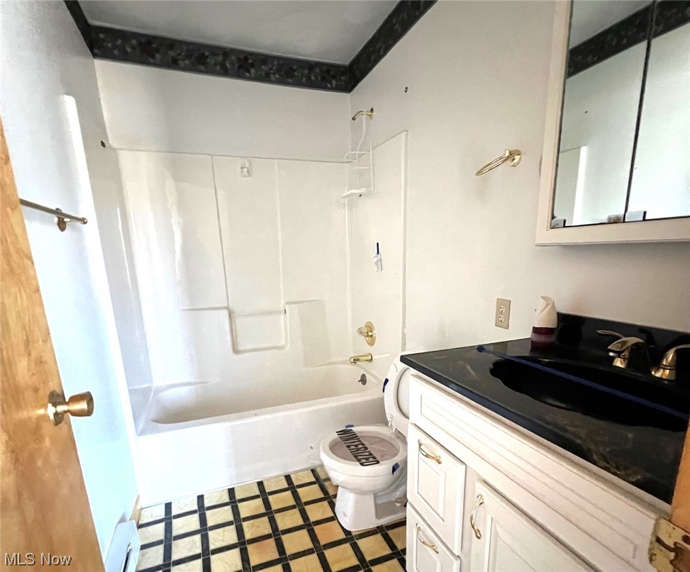 46292 Cedar Way Rogers, OH 44455 - Photo 10 of 12 Full bathroom with tile flooring, toilet, vanity with extensive cabinet space, and shower combination