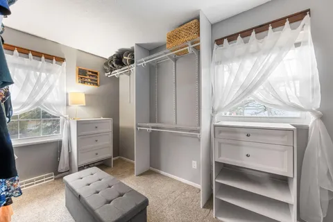 a view of walk in closet with clothes and shoes