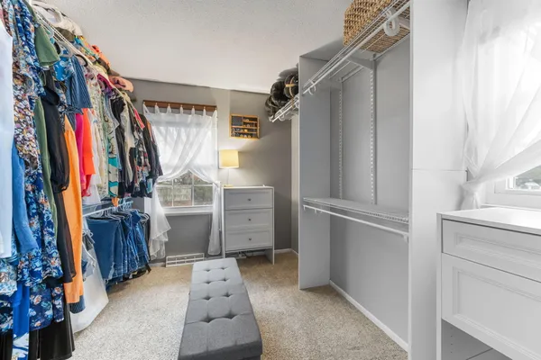 a view of walk in closet with clothes and shoes