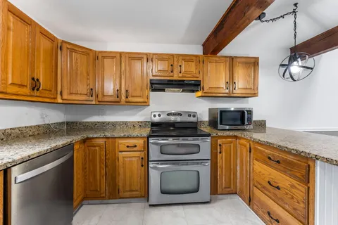 a kitchen with stainless steel appliances granite countertop a sink a stove and cabinets
