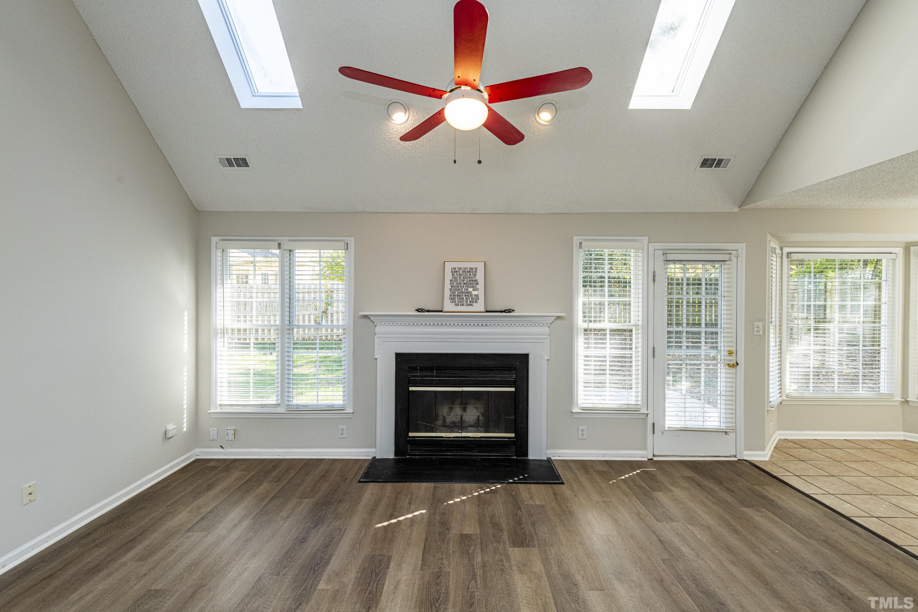 5317 Tilford Lane Raleigh, NC 27613 - Photo 11 of 29 wooden floor fireplace and windows in an empty room