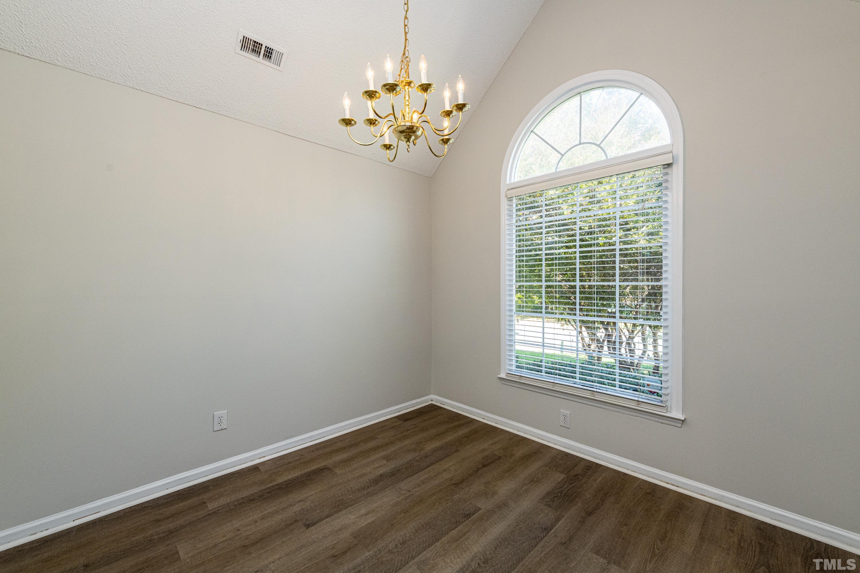 5317 Tilford Lane Raleigh, NC 27613 - Photo 12 of 29 an empty room with chandelier fan and wooden floor