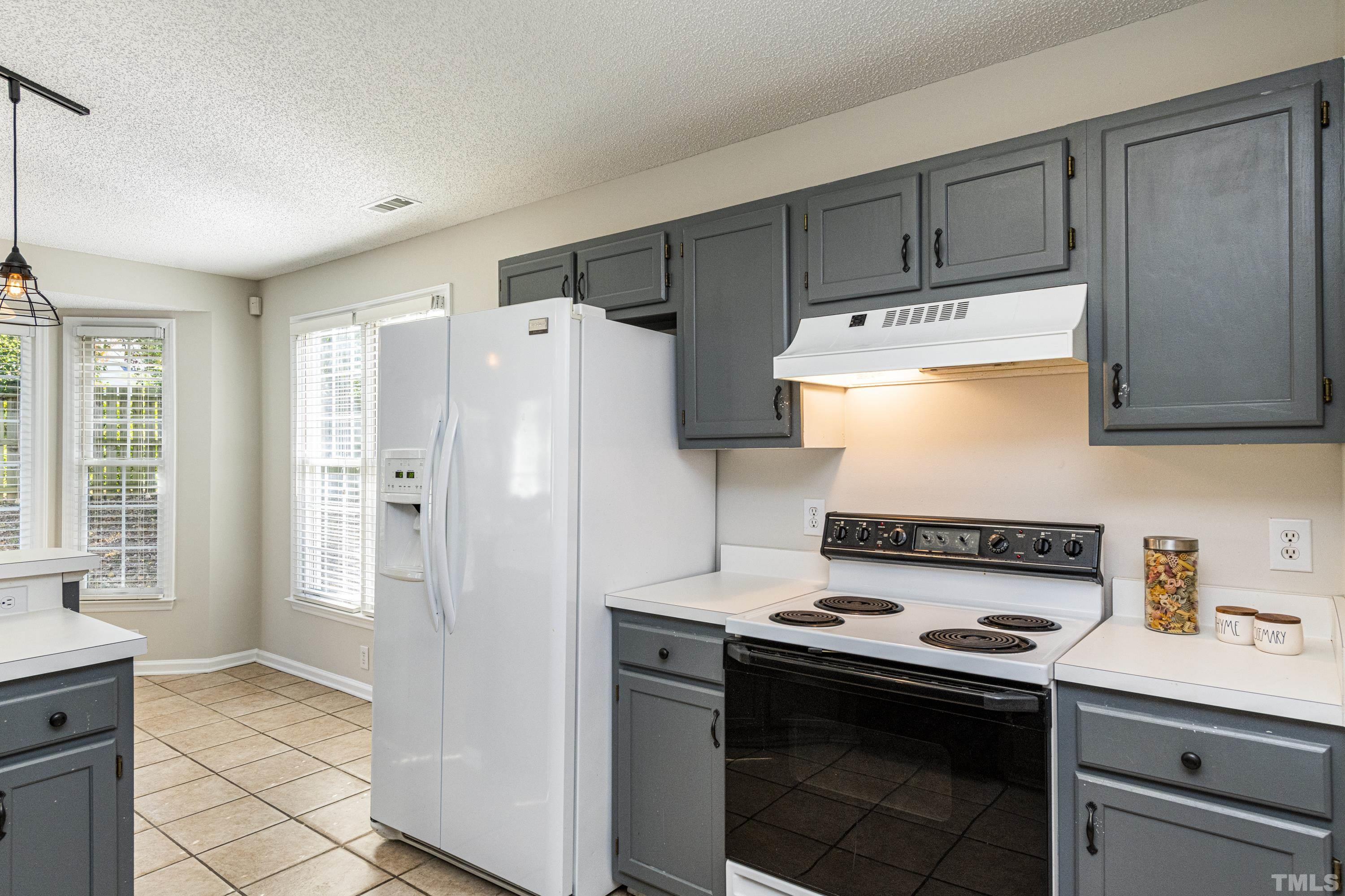 5317 Tilford Lane Raleigh, NC 27613 - Photo 4 of 29 a kitchen with stainless steel appliances a stove a refrigerator and cabinets