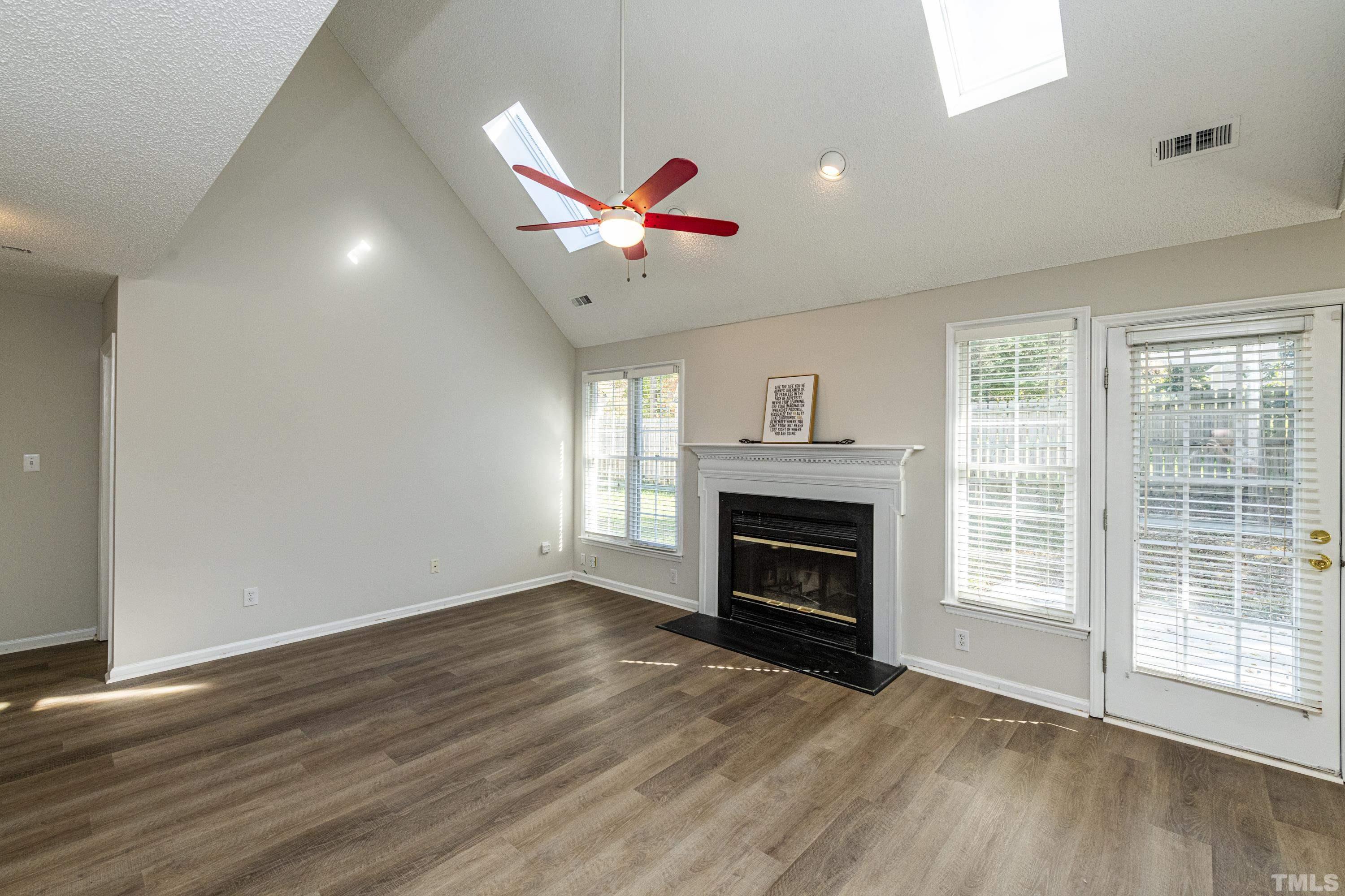 5317 Tilford Lane Raleigh, NC 27613 - Photo 9 of 29 a view of an empty room with wooden floor fireplace and a window