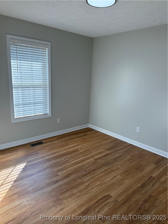 31 Buckboard Lane Autryville, NC 28318 - Photo 12 of 32 an empty room with wooden floor and windows
