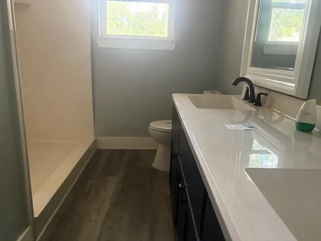 a bathroom with a sink a toilet and a window