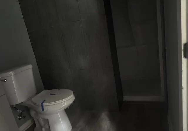 a white toilet sitting next to a shower