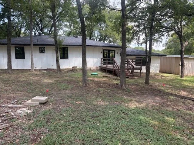 a view of a house with backyard and a tree
