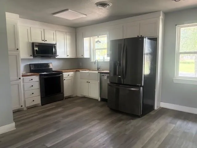 a kitchen with stainless steel appliances granite countertop a refrigerator stove a sink and dishwasher with wooden floor