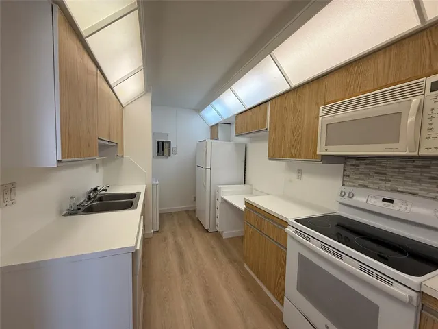 a kitchen with a refrigerator a sink and cabinets