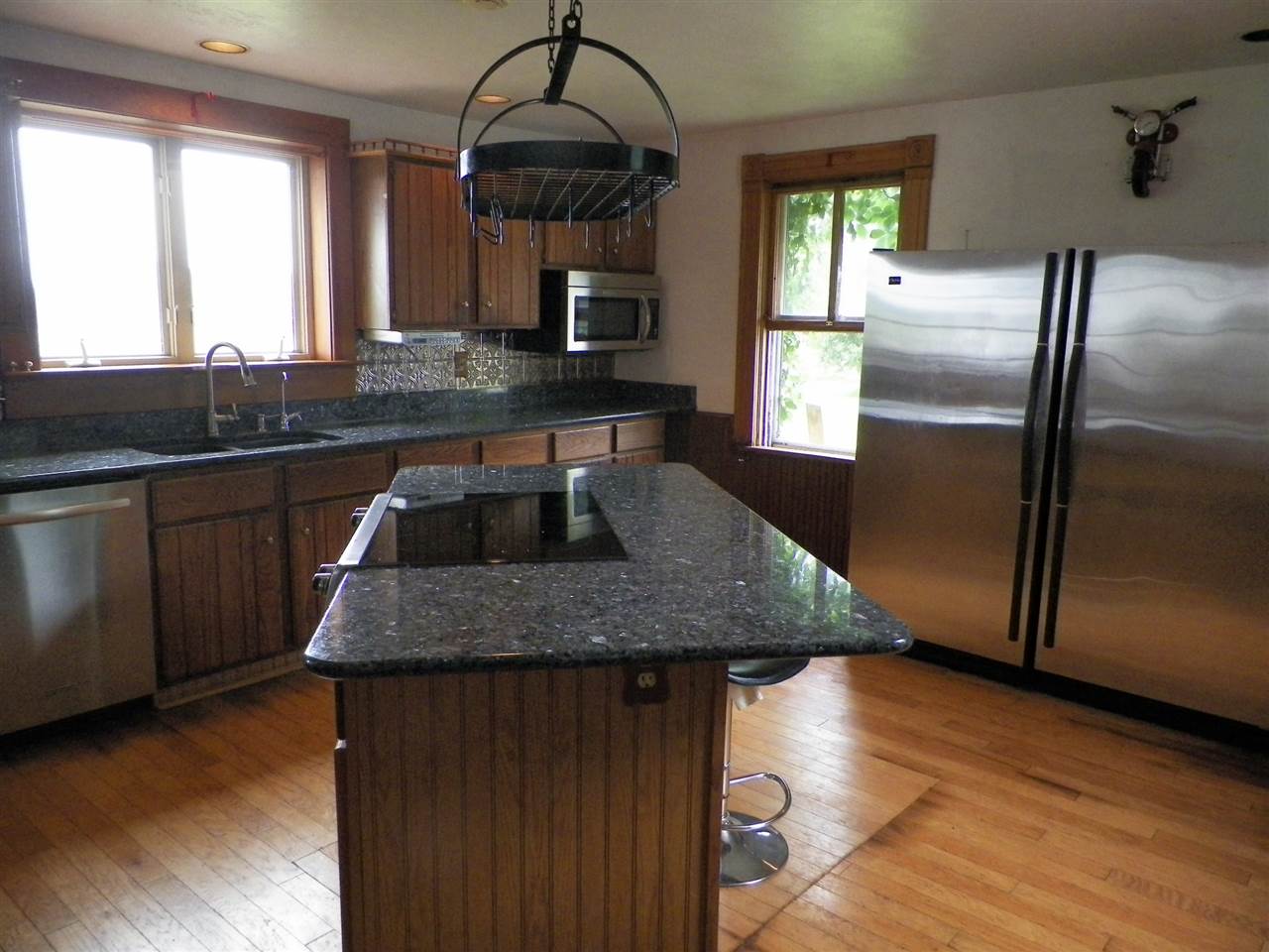 11483 North Tower Road Byron, IL 61010 - Photo 4 of 17 a kitchen with stainless steel appliances granite countertop a sink a microwave cabinets and wooden floor