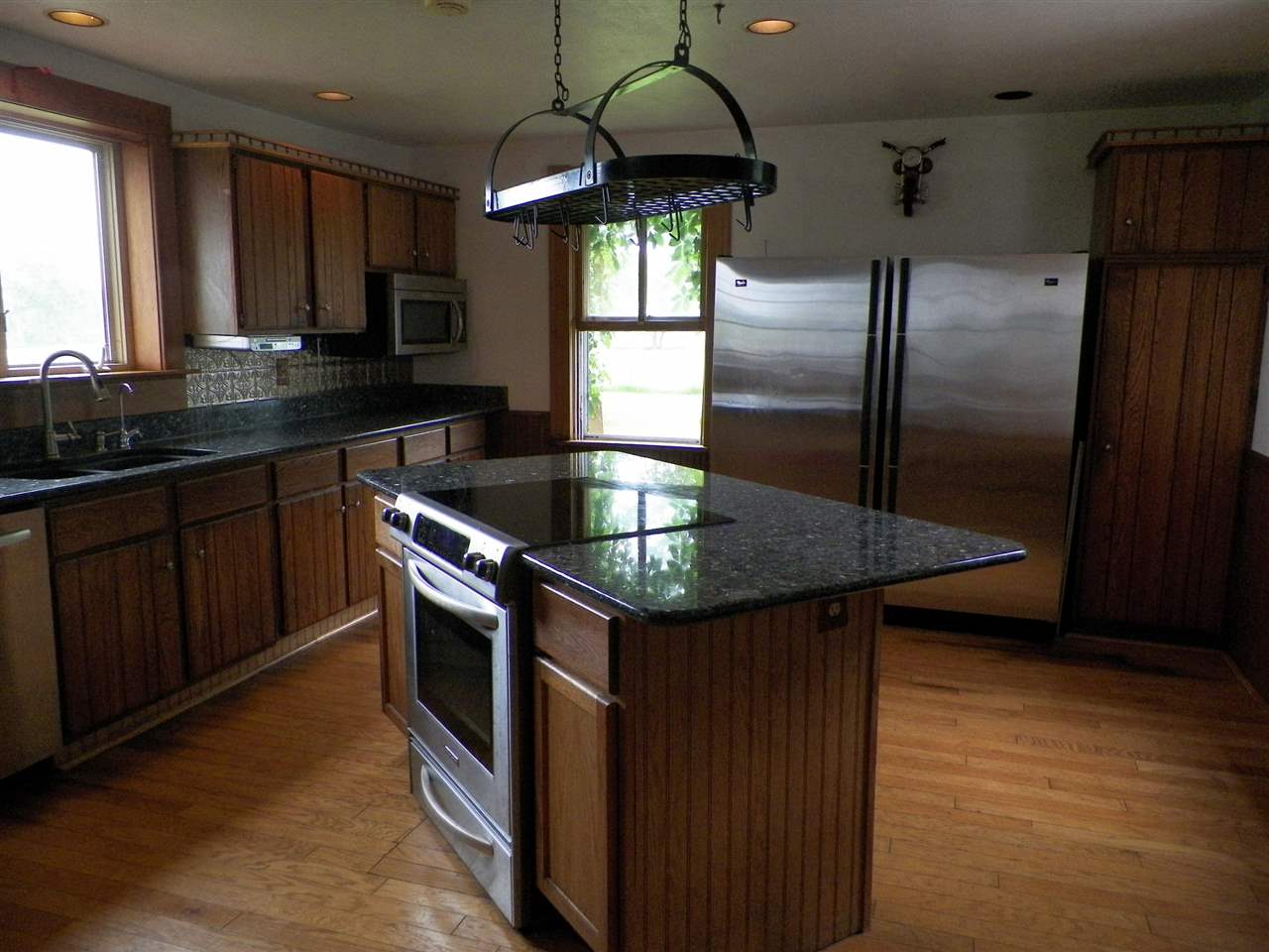 11483 North Tower Road Byron, IL 61010 - Photo 6 of 17 a kitchen with stainless steel appliances granite countertop a sink a microwave cabinets and wooden floor