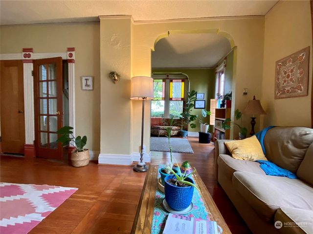 a living room with furniture flowerpot and wooden floor