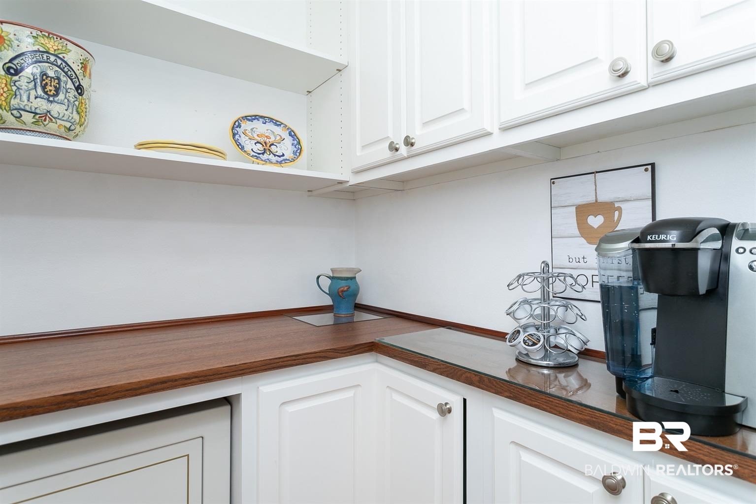 27800 Canal Road, Unit 411 Orange Beach, AL 36561 - Photo 14 of 49 White shaker-style cabinetry with silver-tone hardware, wood-finish countertops, and open shelving