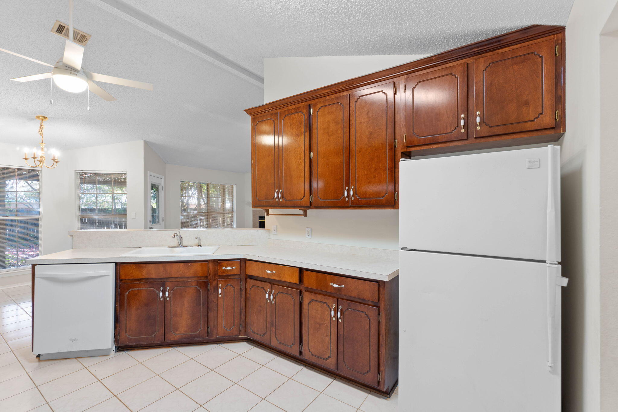 4591 Scarlet Drive Crestview, FL 32539 - Photo 13 of 37 a kitchen with stainless steel appliances granite countertop a refrigerator a sink a stove with wooden cabinets