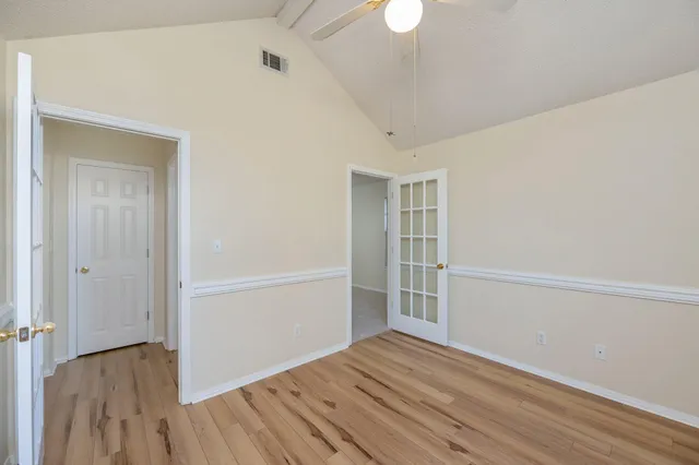 a view of an empty room with wooden floor
