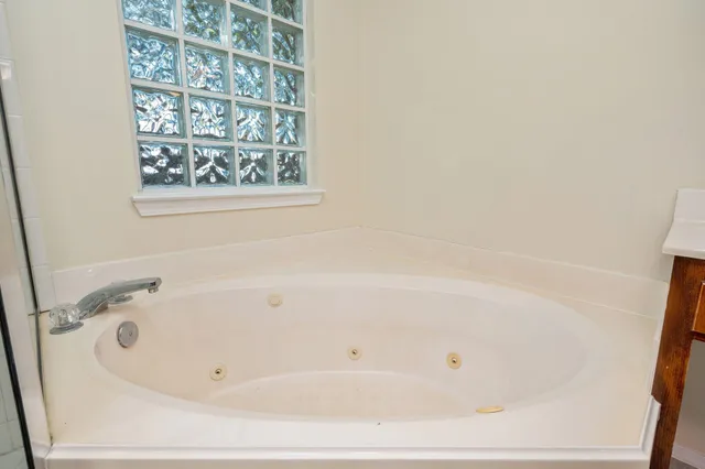 a white bath tub sitting next to a shower