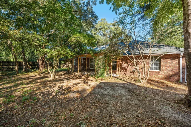 a view of a backyard with table and chairs and wooden fence