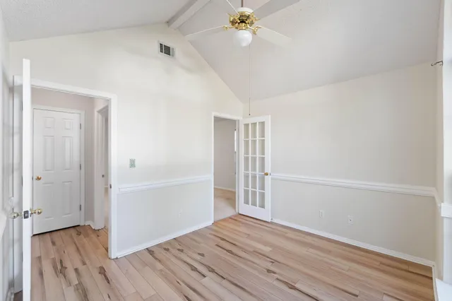 an empty room with windows and fan