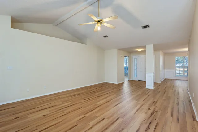 a view of an empty room with wooden floor
