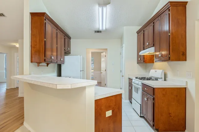 a kitchen with stainless steel appliances a sink stove and cabinets