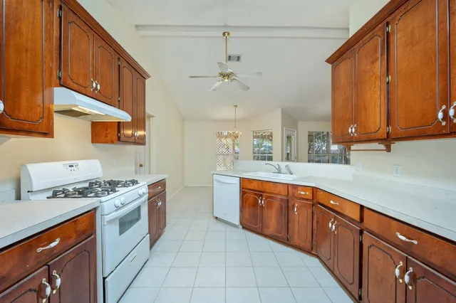 a kitchen with stainless steel appliances granite countertop a stove a sink and a refrigerator