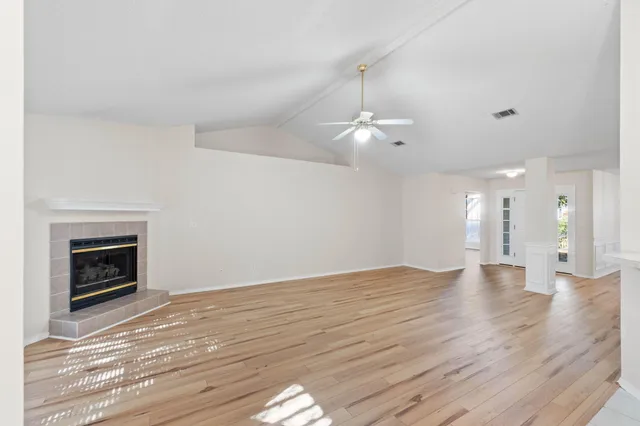 a view of an empty room with window and cabinet