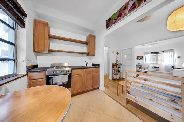 a room with kitchen island a sink and a stove with wooden floor