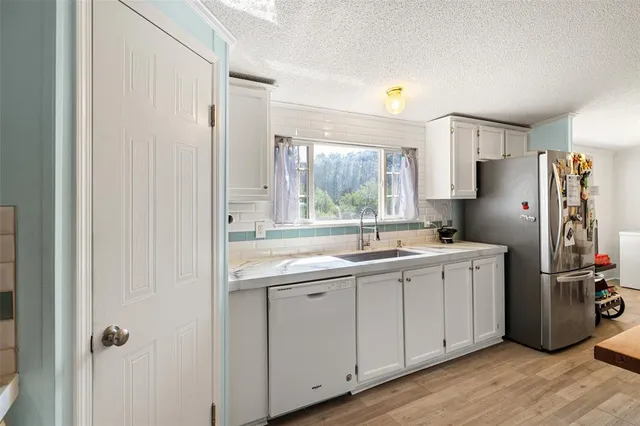 a kitchen with a sink cabinets stainless steel appliances and a window
