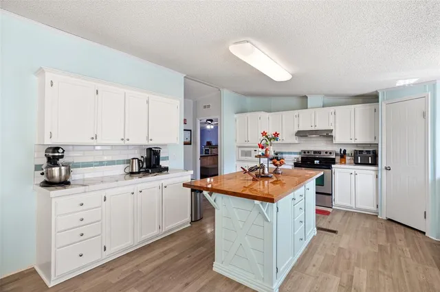 a kitchen with stainless steel appliances kitchen island granite countertop a sink and cabinets