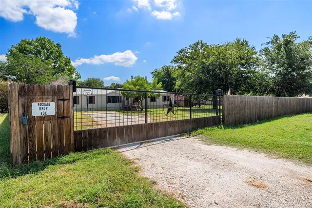 a view of a backyard with wooden fence