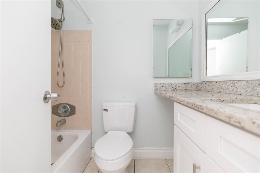 7531 Abonado Road, Unit 1 Tampa, FL 33615 - Photo 20 of 26 a bathroom with a granite countertop toilet sink and mirror