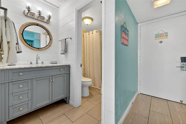 a bathroom with a granite countertop toilet sink and mirror