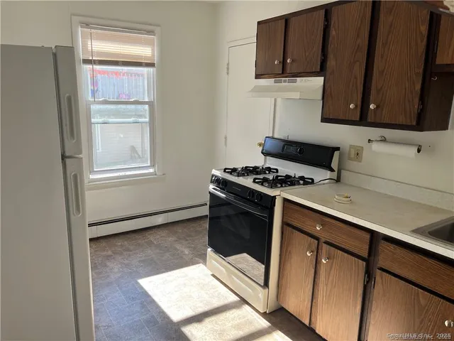a kitchen with wooden cabinets and a stove top oven
