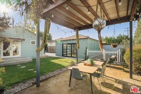 a view of a patio with a table chairs and a backyard