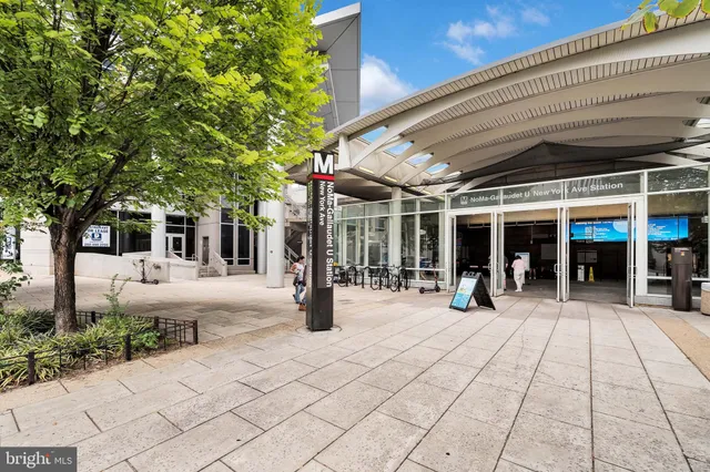 a sign board with a yard and large trees
