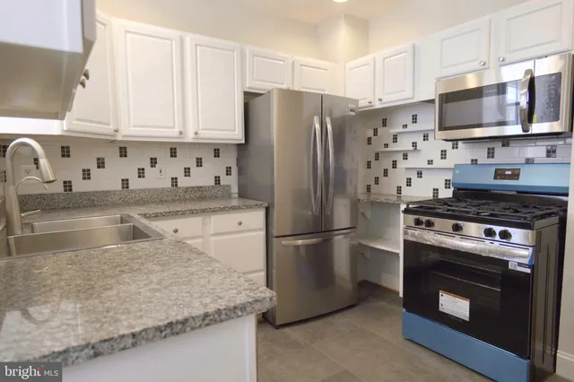 a kitchen with stainless steel appliances granite countertop a refrigerator stove and microwave