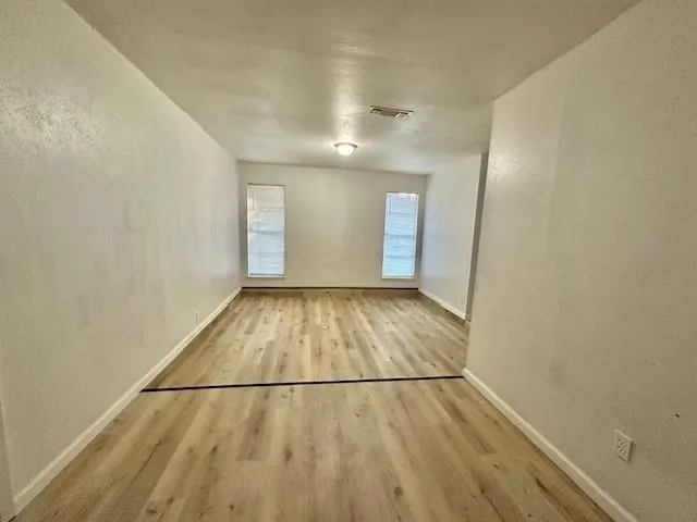 an entryway of an empty room with wooden floor