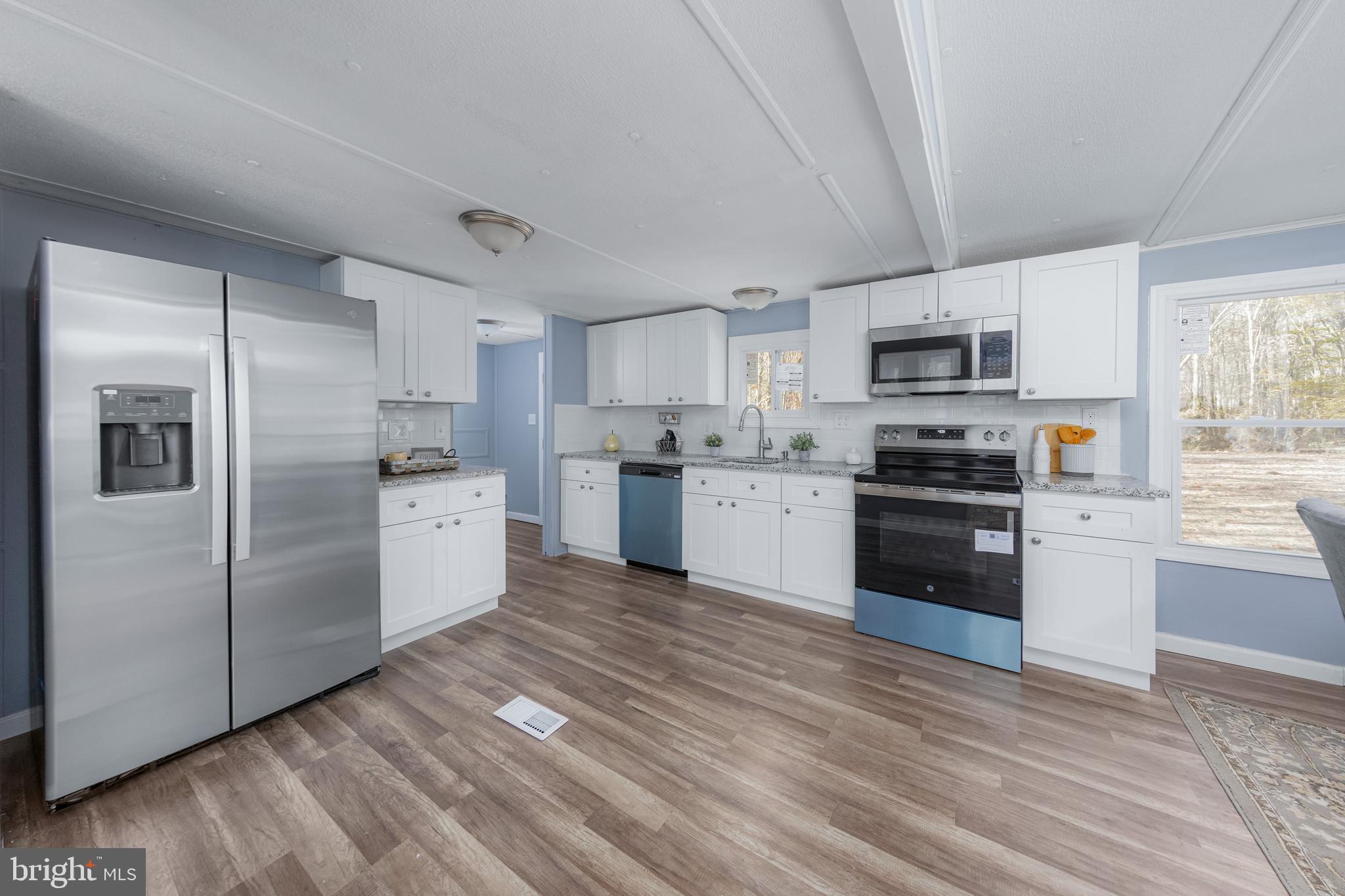 42 Waterworks Road Salem, NJ 08079 - Photo 8 of 20 a kitchen with stainless steel appliances granite countertop a refrigerator a stove top oven a sink and dishwasher with wooden floor