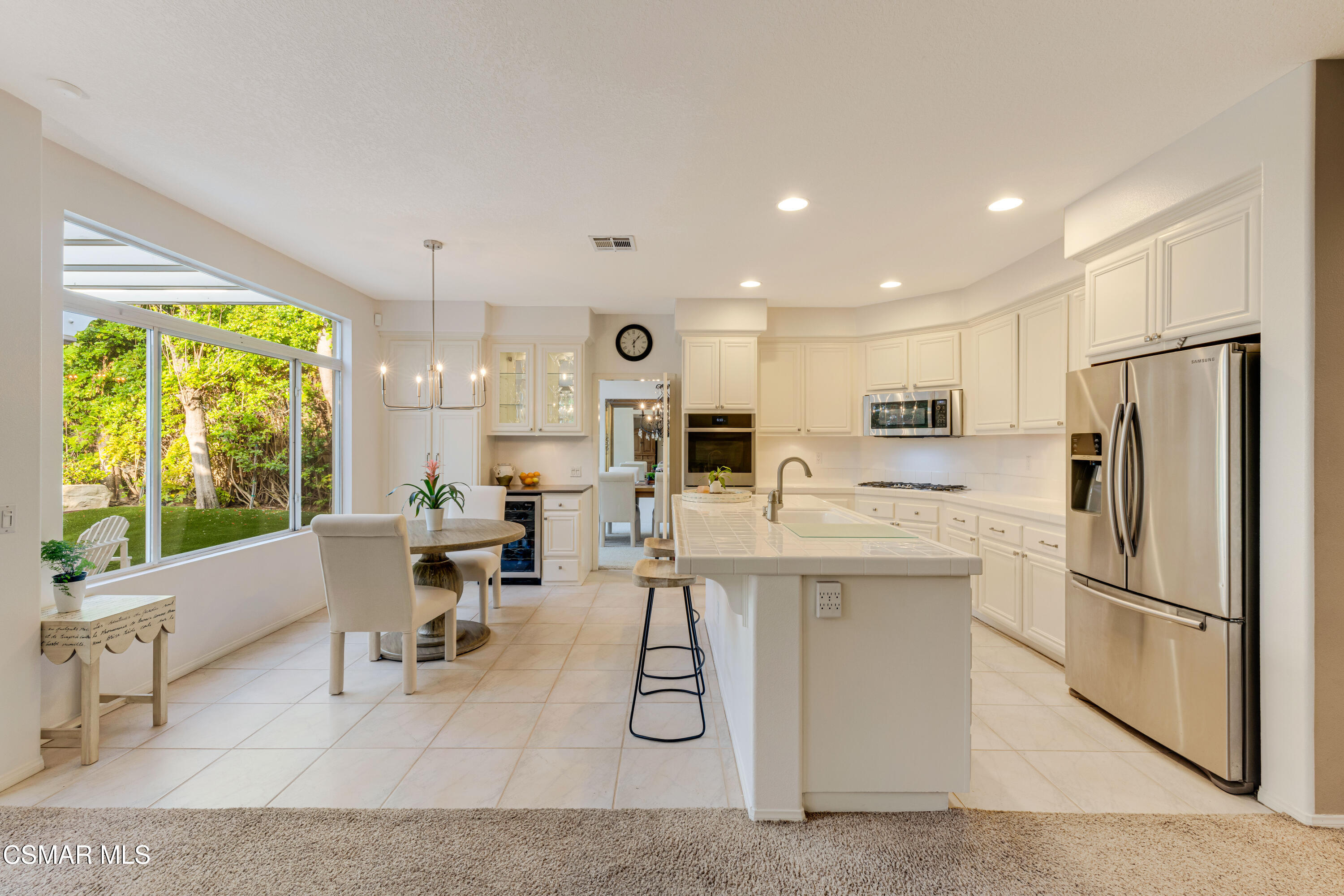 15633 Harte Lane Moorpark, CA 93021 - Photo 22 of 64 a kitchen with stainless steel appliances kitchen island granite countertop a refrigerator oven a sink dishwasher and white cabinets with wooden floor