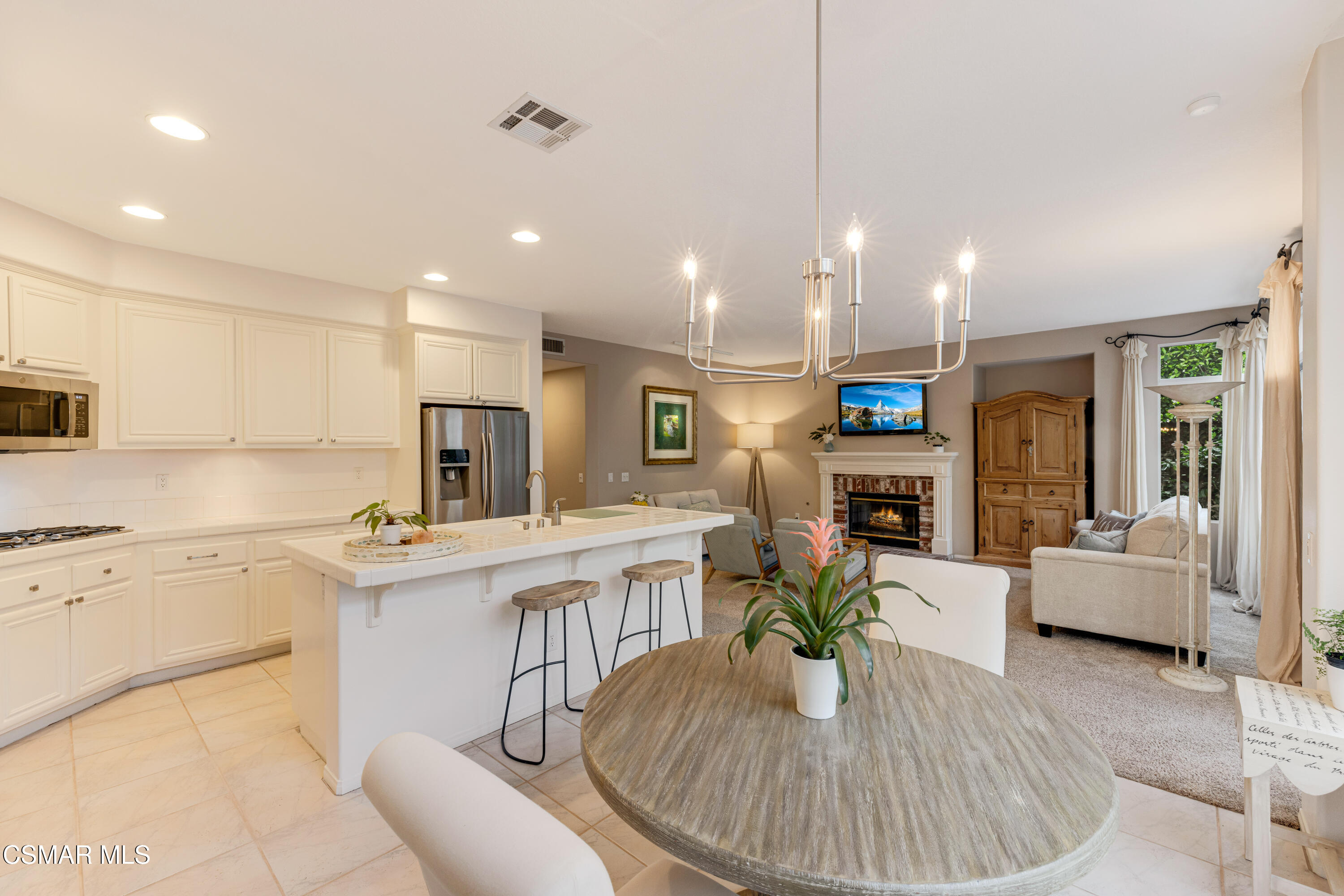 15633 Harte Lane Moorpark, CA 93021 - Photo 25 of 64 a kitchen with stainless steel appliances kitchen island granite countertop a stove a sink a refrigerator a couch and white cabinets with wooden floor