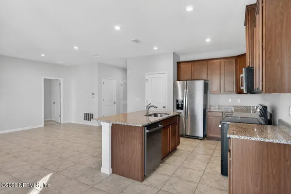 a kitchen with stainless steel appliances granite countertop a stove a refrigerator and a refrigerator