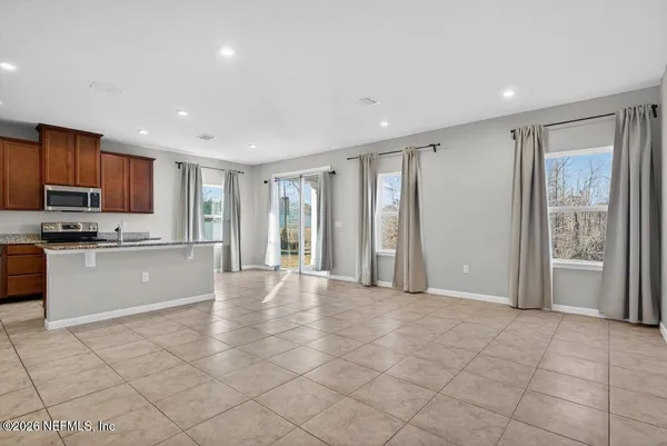 a view of a kitchen with microwave and refrigerator