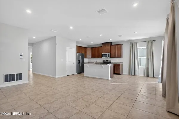 a view of kitchen with granite countertop a refrigerator oven a sink and a granite counter top