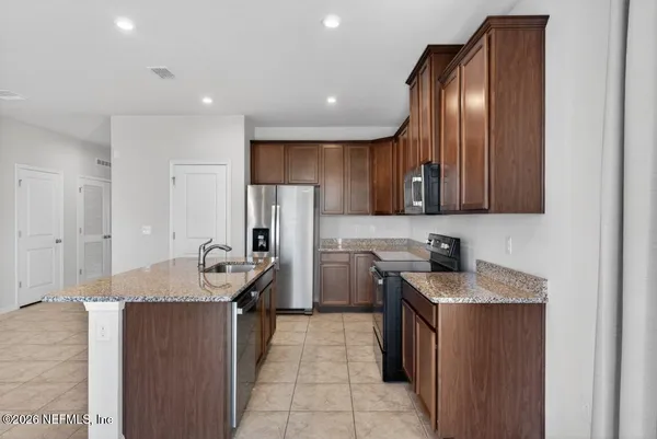 a kitchen with stainless steel appliances granite countertop a sink stove and refrigerator