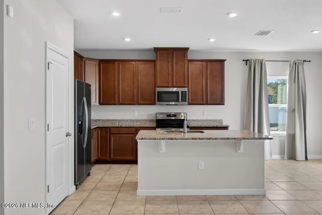 a kitchen with stainless steel appliances granite countertop a stove a refrigerator and a refrigerator